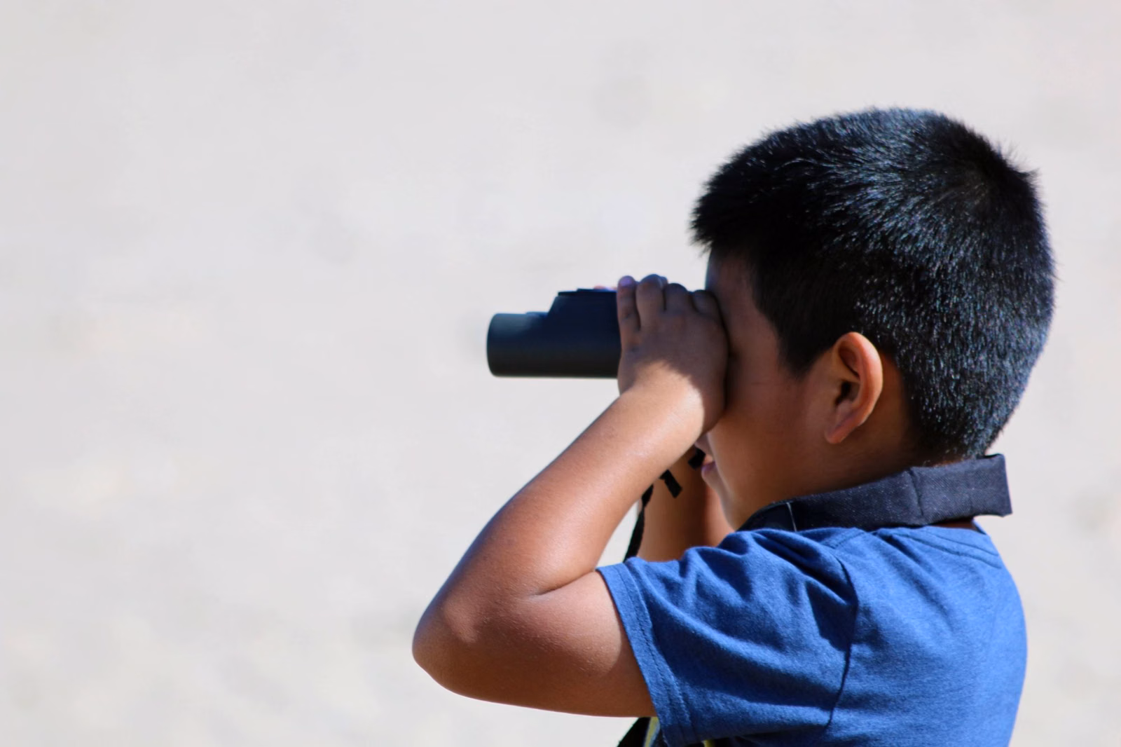 A boy looking through binoculars